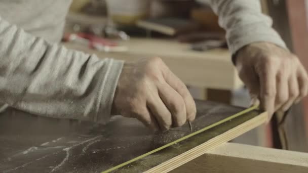 Tischler messen Holzbrett für Holzbrett, machen Zeichen für Nägel. Möbel - Filmmaterial, Video