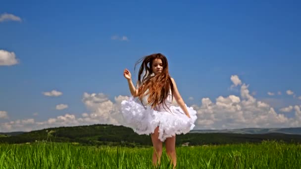Cute Girl skoki w zielony łąka - Materiał filmowy, wideo