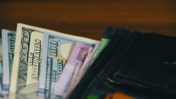 Peníze v peněžence otočení na dřevěný stůl - Záběry, video