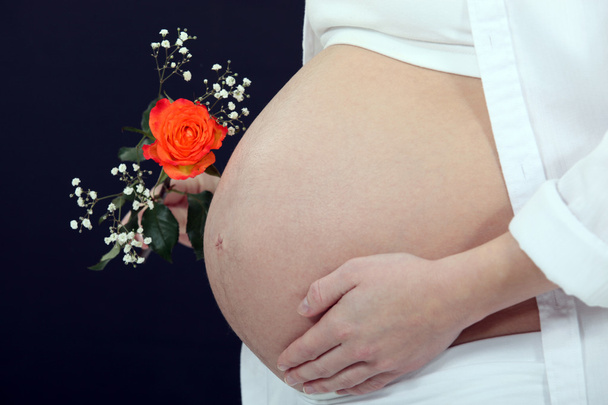 Pregnant woman holding flower - 写真・画像