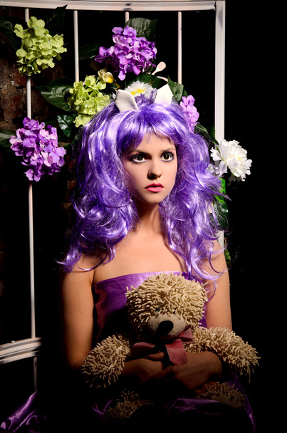 Cosplay meisje in paarse pruik met speelgoed en bloemen - Foto, afbeelding