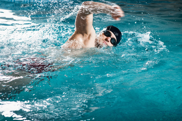 Young man swimming the front crawl in a pool - Foto, imagen