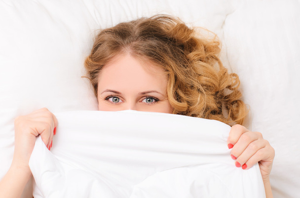 young woman hiding under white blanket - Photo, Image