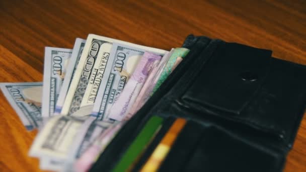 Bir m-cüzdan ahşap bir masa üzerinde dönen para - Video, Çekim