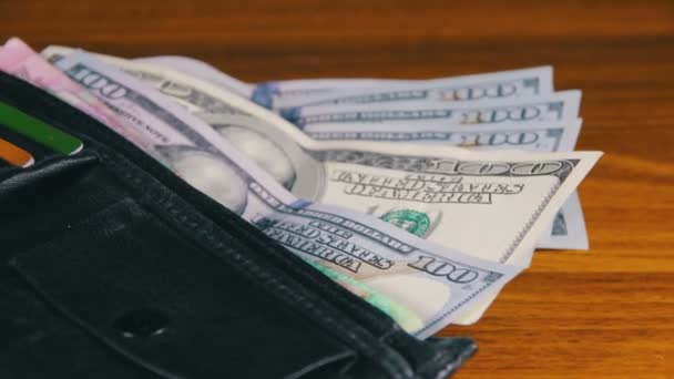 Bir m-cüzdan ahşap bir masa üzerinde dönen para - Video, Çekim