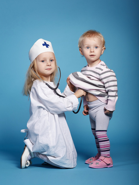 две симпатичные девчонки играют врача
 - Фото, изображение