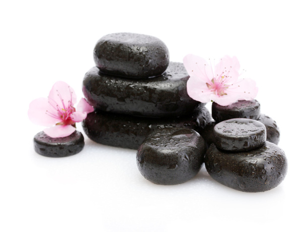 Spa stones with drops and pink sakura flowers isolated on white - Foto, afbeelding