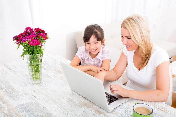 Mother and Daughter with a Laptop at home - Foto, afbeelding