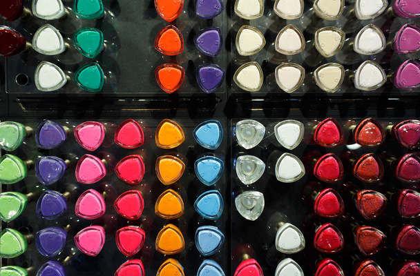 Set of different nail varnishes on shelves in cosmetic store - Φωτογραφία, εικόνα