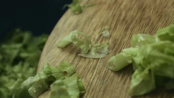 Close up de mulheres mãos adicionando saborosas folhas de alface fresca em uma tigela com outros ingredientes preparados para uma salada de legumes
. - Filmagem, Vídeo