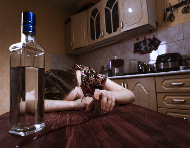 Sleeping drunk woman with inverted glass in hand - Foto, afbeelding