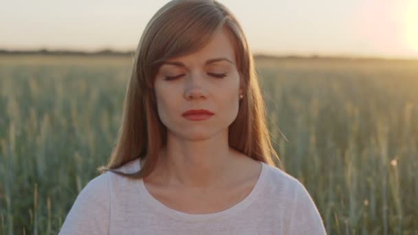 Woman opens her eyes after meditation at sunset - Footage, Video