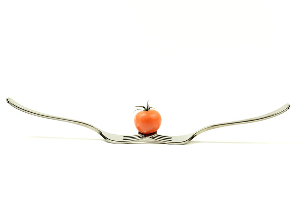 ντομάτα σε ισορροπία σχετικά με δύο πιρούνια - Φωτογραφία, εικόνα