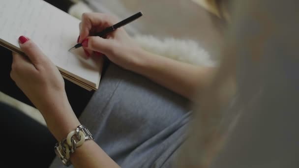 Escrita feminina no bloco de notas com uma caneta
 - Filmagem, Vídeo