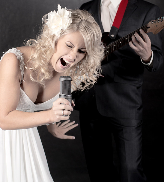 Fashion model in wedding dress with microphone in hand - Photo, Image