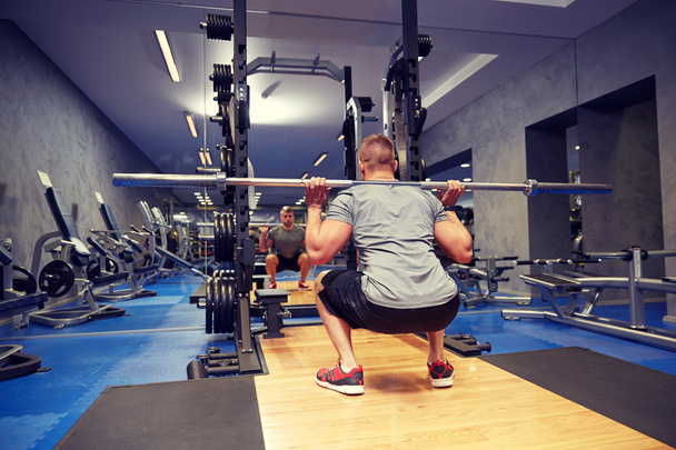 jeune homme flexion des muscles avec bar dans la salle de gym
 - Photo, image