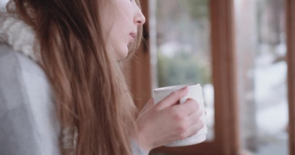 Woman drinks tea and working on a laptop - Кадри, відео