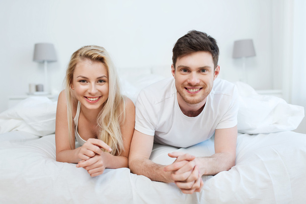 happy couple lying in bed at home - Фото, зображення
