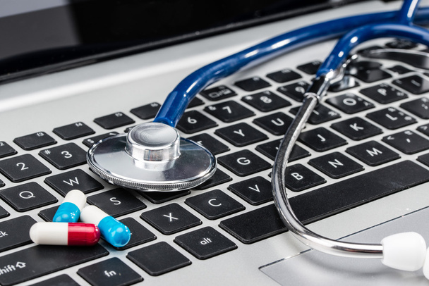 Medycznych badań, stetoskop i kapsułki na klawiaturze laptopa - Zdjęcie, obraz