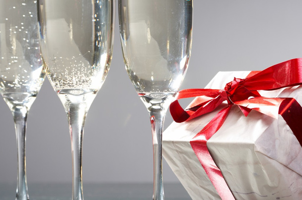 kadeh şampanya, hediyeleri kırmızı bantları ve yay - Fotoğraf, Görsel
