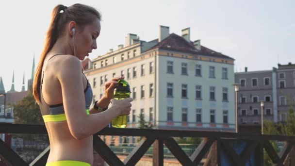 Runner woman drinking water and running - Кадри, відео