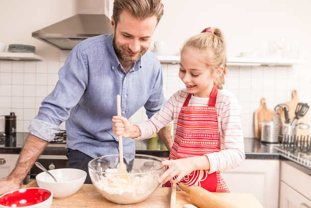 Father and daughter preparing cookie dough in the kitchen - Foto, Bild