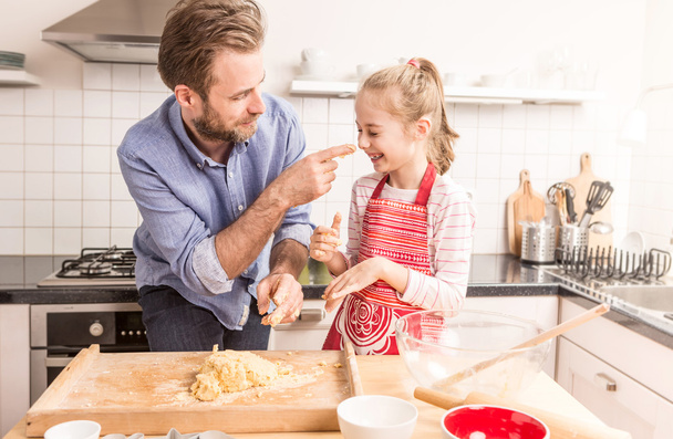 Glücklicher Vater und Tochter bereiten Plätzchenteig in der Küche zu - Foto, Bild