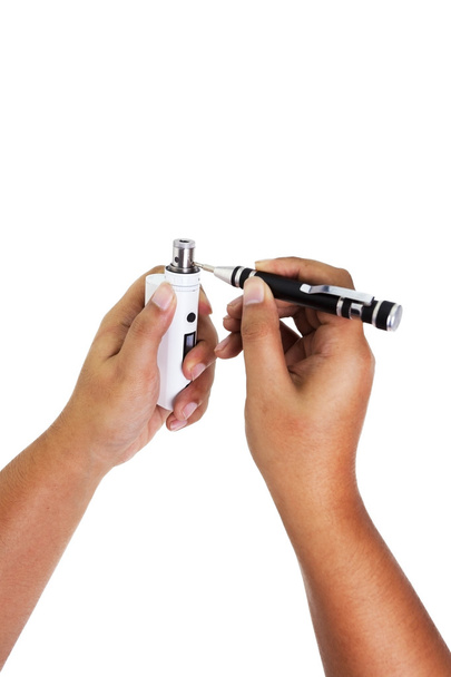 Menselijke hand repareren een verstuiver herbouwen staat van elektronische sigaret, vaper. met behulp van schroevendraaier te openen van een spoel. op witte achtergrond. - Foto, afbeelding
