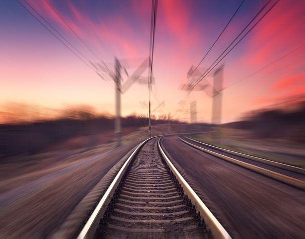 Railway station at colorful sunset with motion blur effect. Rail - Valokuva, kuva
