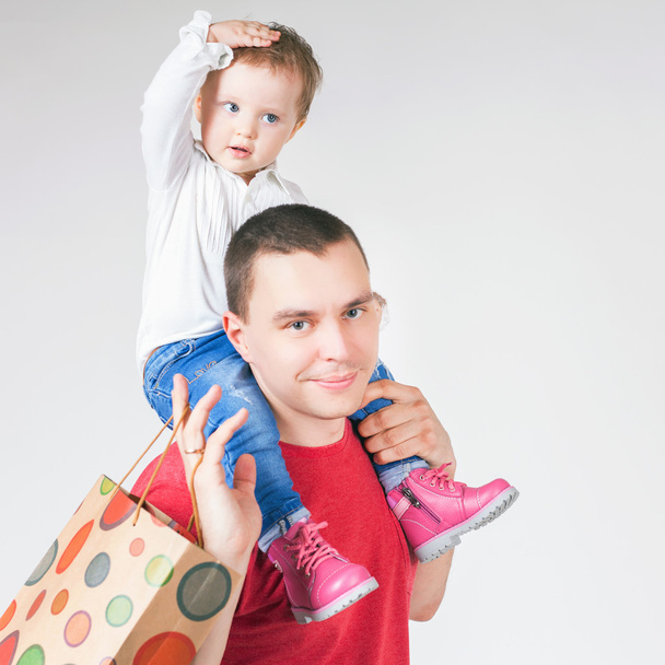 Happy father and funny baby holding bags with purchases - Foto, Imagem