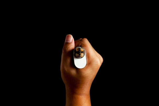 людська рука тримає відновлену здатну атомайзерну електронну сигарету. вид зверху. фон чорного кольору
. - Фото, зображення