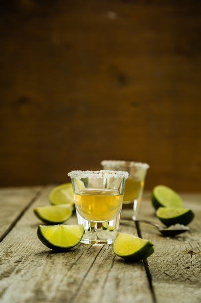 Gold tequila shots on rustic wood background - Foto, imagen