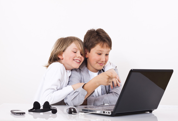 Two cheerful boys looking something on lap top - Фото, изображение
