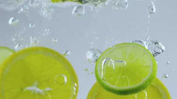 limes and oranges dropped in water - Footage, Video