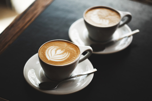 Deux tasses de cappuccino sur table noire
 - Photo, image