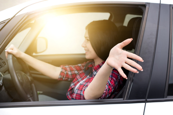 Жінка водить машину з рукою з вікна
 - Фото, зображення