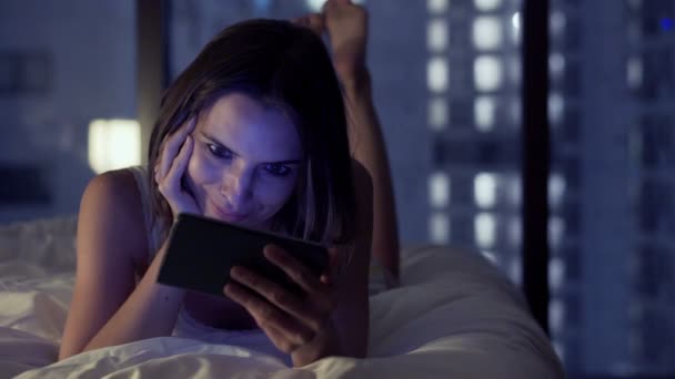 woman watching movie on smartphone on bed - Materiał filmowy, wideo