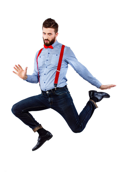 stylish guy in the blue shirt with red bowtie and suspenders isolated on white.  jumping, emotion, crazy, awesome. - Valokuva, kuva