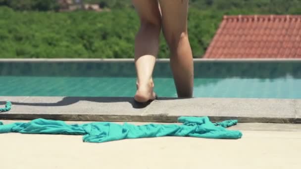 Woman taking off pareo and walking into pool - Materiał filmowy, wideo