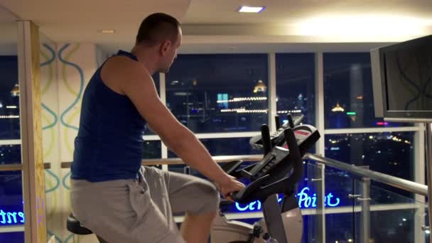 Hombre a caballo bicicleta estacionaria en el gimnasio
  - Metraje, vídeo