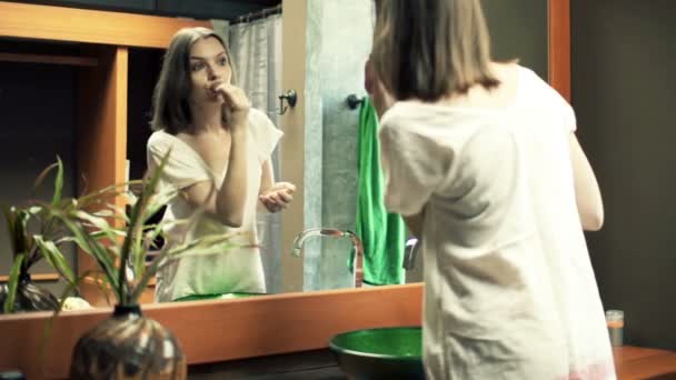Woman applying makeup, powder on her face - Filmati, video