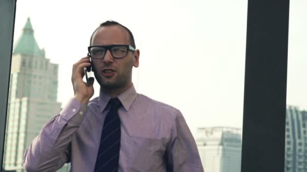 Young businessman talking on cellphone in city - Materiał filmowy, wideo