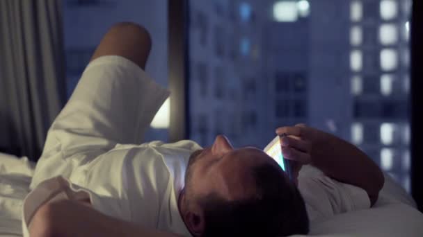 man talking on cellphone on bed  - Imágenes, Vídeo