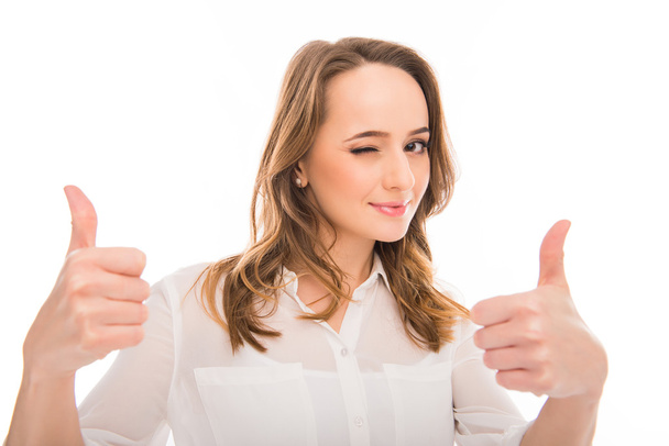 Cheerful young businesswoman showing thumbs up and winking - Foto, Imagem