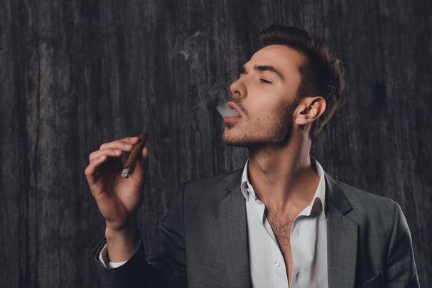 Close up portrait of pretty businessman smoking a sigar - Zdjęcie, obraz
