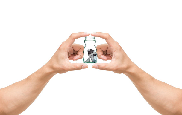 man hands catching the Sad woman sitting alone in a jar on white background - Photo, Image
