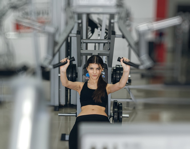 Girl performs exercises on the simulator - Foto, imagen