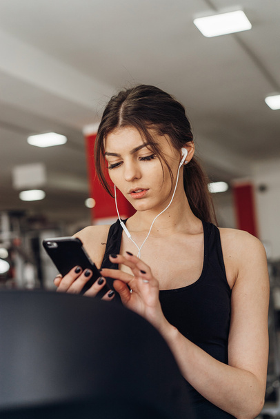 Beautiful girl with a phone in the gym - Foto, Imagem