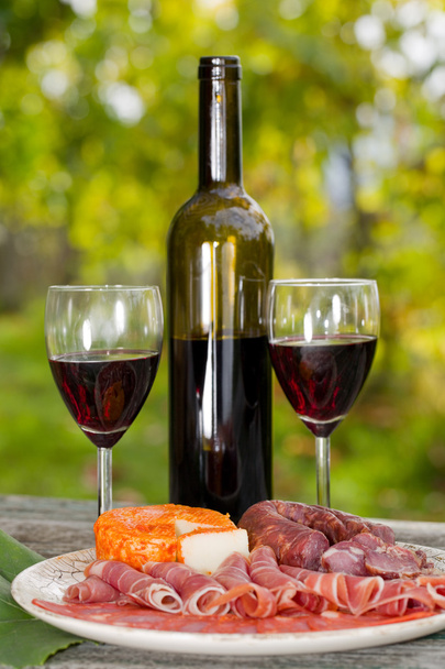 Cadre de vie champêtre avec vin, fruits, fromage et viande. Extérieur
 - Photo, image