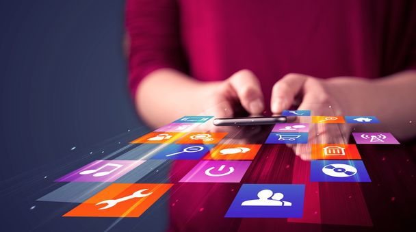 Frau hält Smartphone mit bunten Applikationssymbolen in der Hand  - Foto, Bild